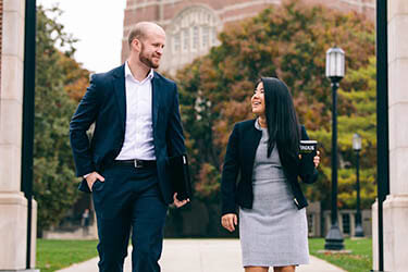 a male and female mba student walking on campus